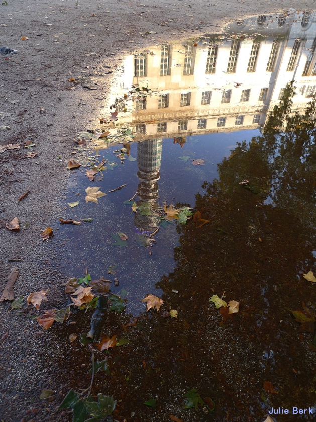Post Office Tower reflected in puddle in Fitzroy Square